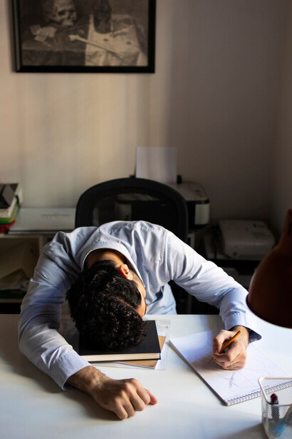 A stressed man working late at his desk, overwhelmed by corporate burnout