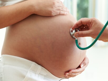 Un médico examina a una mujer embarazada