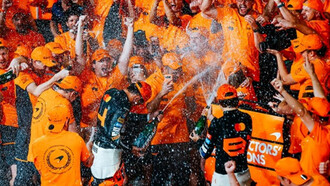 Lando Norris, Oscar Piastri e il Team davanti al box McLaren in seguito al Gran Premio di Abu Dhabi, 2024