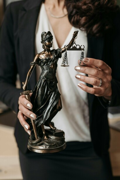 A estátua representa equilíbrio, lei e julgamento. Em contraste com os casos discutidos, o símbolo idealizado da justiça parece distante da realidade