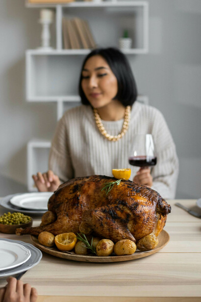 Donna con bicchiere di vino davanti al tacchno ripieno
