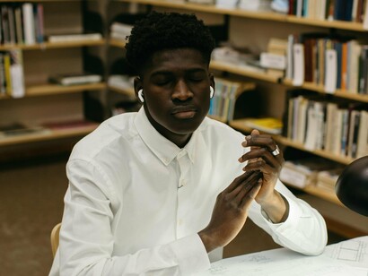 Homem em biblioteca. A integração do conhecimento empírico e do conhecimento acadêmico pode gerar uma produção de conhecimento mais rica, prática e contextualizada. Essa combinação permite que a teoria e a prática se complementem, resultando em inovações, soluções eficazes e avanços em diversas áreas