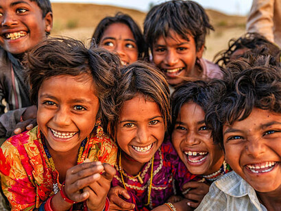 A group of happy Indian children from various ethnic backgrounds in a desert village, India, showcasing the cultural diversity studied in the Indian Genome Project