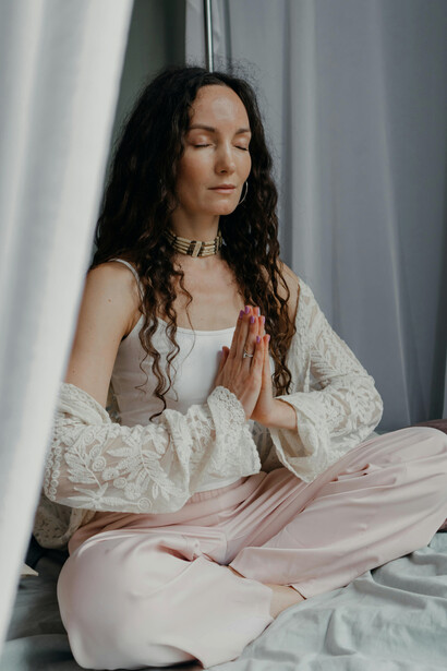 A serene woman sits in meditation indoors, creating a sense of calm, balance, and mindfulness during her morning routine at home