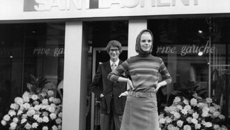 Yves Saint Laurent y una de sus modelos frente a su tienda en la Rive gauche de París