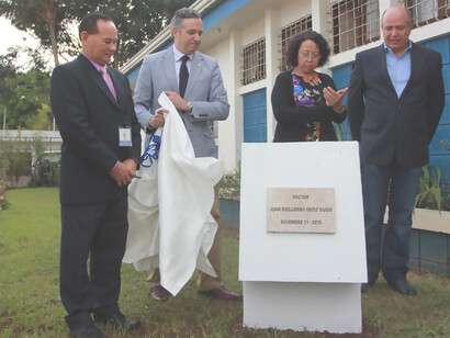 Individuals stand proudly in front of the monument dedicated to Dr. Juan Guillermo Ortiz Güier, paying tribute to his remarkable contributions to healthcare, Costa Rica