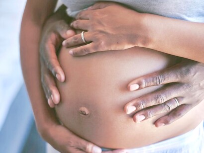 Esposo e mulher abraçam bebê na barriga