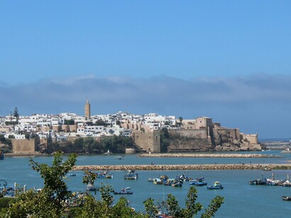 Fishing boats in calm waters beneath the fortified walls of Rabat, Morocco, representing the country’s relationship with the sea and its strategic coastal position