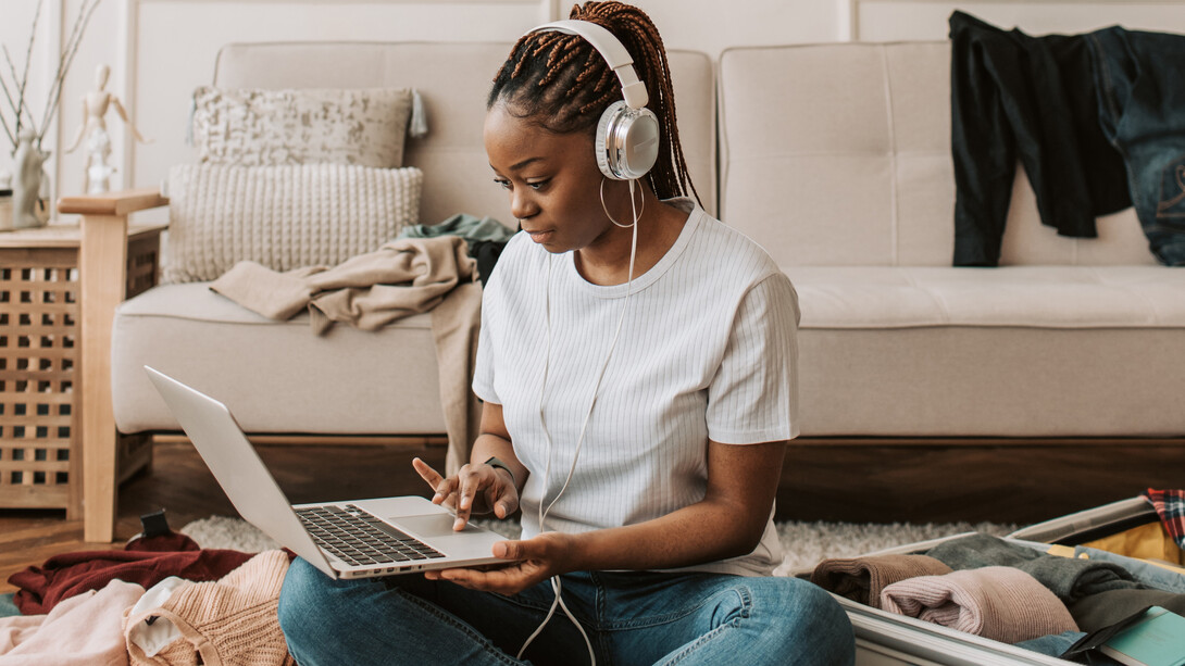 Mulher coloca sua playlist de música favorita enquanto arruma sua mala para uma nova fase de sua vida que irá começar