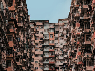 Towering apartment blocks in Hong Kong rising above the streets, symbolising the intersection of extreme urbanisation and social inequality