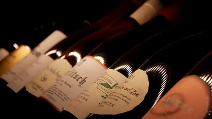 White labeled wine bottles on brown wooden table