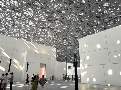Les jeux d’ombre et de lumière du dôme du Louvre Abu Dhabi enveloppent les visiteurs, créant un dialogue unique entre architecture, nature et patrimoine universel