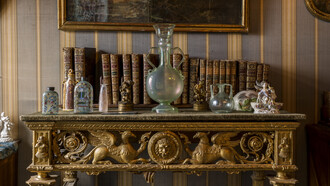 Fondazione "Il Vittoriale degli Italiani", Prioria. Salotto Baccara, ampolla con doppio manico arricciolato; a corredo, vari flaconi. Fotografie di Marco Beck Peccoz, catalogo Silvana Editoriale,  mostra "D’Annunzio e l’Arte del Profumo. Odorarius Mirabilis" a cura di Paola Goretti 

