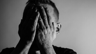 A man touching his face in depressed mode