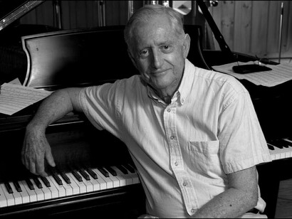 Eddie Higgins appoggiato al pianoforte 