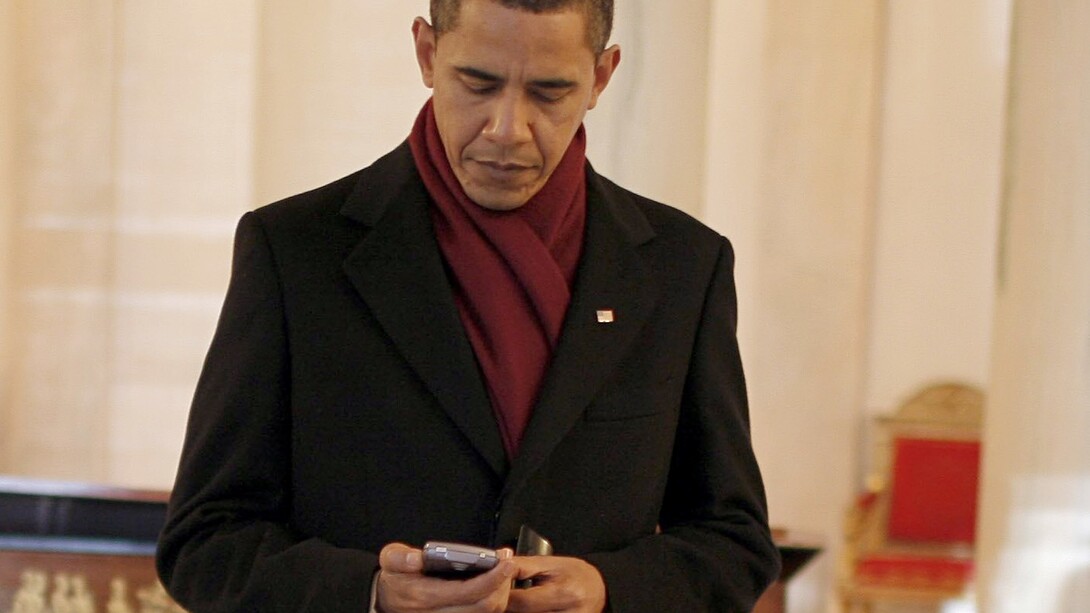 Barack Obama consulta su teléfono móvil