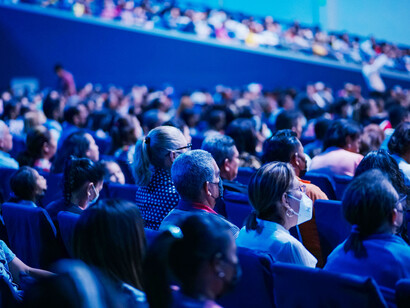 A soft blue light falls over the audience in the theatre