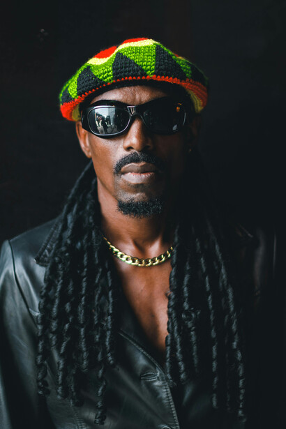 Portrait of a man wearing sunglasses and a hat, inspired by classic reggae aesthetics