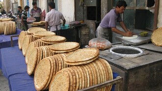 Panettieri di strada che sfornano naan nel cuore di Kashgar, Cina. Foto di Giò Barbieri