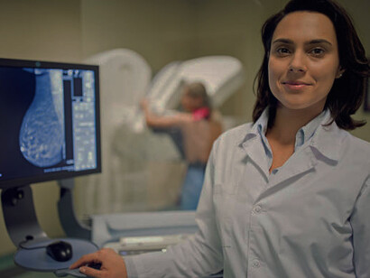 A doctor uses a mammography X-ray scanner in a hospital setting, integrating artificial intelligence (AI) to improve the accuracy of breast cancer detection and diagnosis