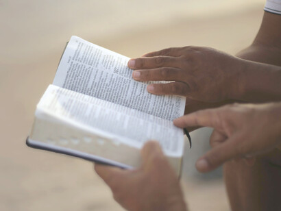 Niños ojean las líneas de una Biblia. En el cielo les espera un lugar privilegiado, aunque no lo sepan