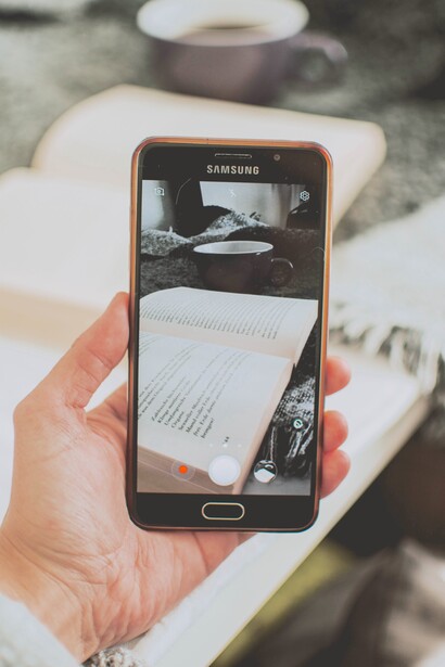 Pessoa tira foto de um livro com o celular