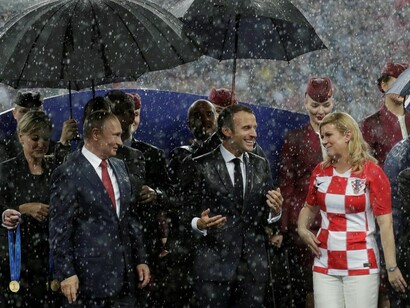 El diluvio se desató durante la entrega de la Copa, pero a Macron y Kolinda Grabar, presidente de Croacia, no parece importarles bajo la mirada divertida de Putin