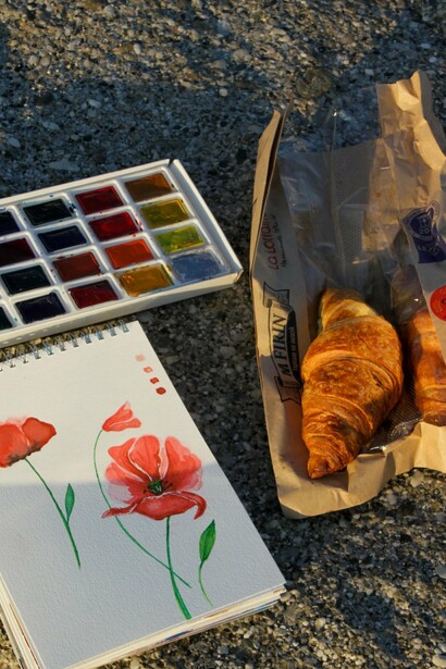 Materiais de pintura e um caderno aberto revelam o hábito de registrar paisagens e ideias sempre que a inspiração surge. Para François, cada caminhada pela cidade é uma oportunidade de criar