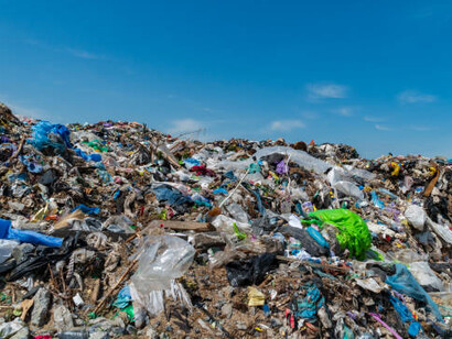 The sight of a massive landfill spilling over with plastic and waste against a clear blue sky powerfully illustrates the growing crisis of pollution and its impact on ecosystems