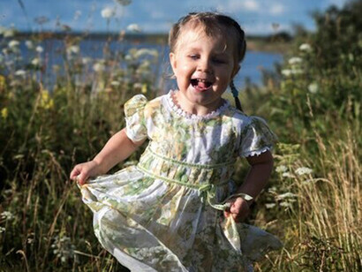 Niña corriendo y riendo en la yerba