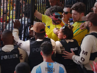 The police attempt hold the gates from the flooding fans