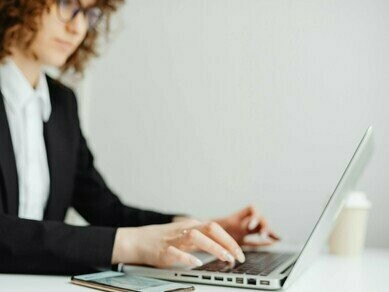 Mulher trabalha em seu computador e smartphone. A entrada do Threads no mercado publicitário abre novas possibilidades para marcas que buscam diversificação nos investimentos em mídia digital