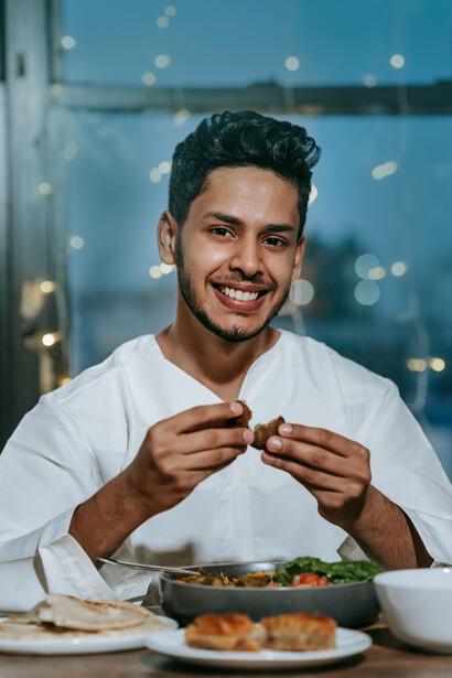 Hombre partiendo un falafel por la mitad