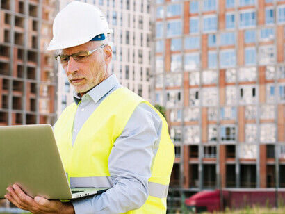 Man wearing a helmet working on a construction site with AI-driven sustainable architecture and smart building technologies