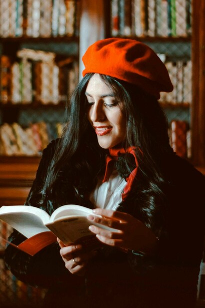 Mulher lê livro em biblioteca. Com a chegada do século XX, a leitura se transformou novamente. A alfabetização cresceu rapidamente, impulsionada pela educação pública. Editoras começaram a publicar livros mais baratos, como os famosos pocket books

