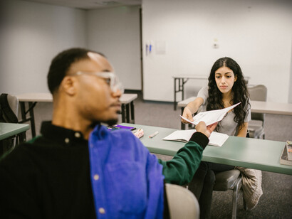 Alunos em sala de aula compartilham uma atividade de literatura após voltarem presencialmente a universidade