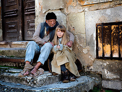 A father and his daughter sitting on the street, affected by homelessness