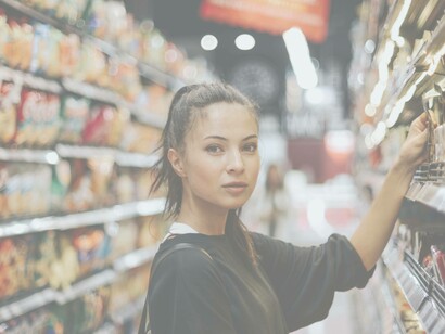A grocery shopper trying to decide which product is best when a friendly employee asks if he could be of service
