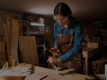 Discover the power of determination as a girl in the garage engages in woodcutting, embodying resourcefulness and drive towards her goals