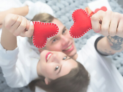 A couple cuddling with tiny heart-shaped toys, embodying love and tenderness