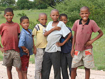 San boys from a village near Tsumkwe, Namibia, play during the rainy season, amidst the challenges of maldevelopment and malnutrition in the region