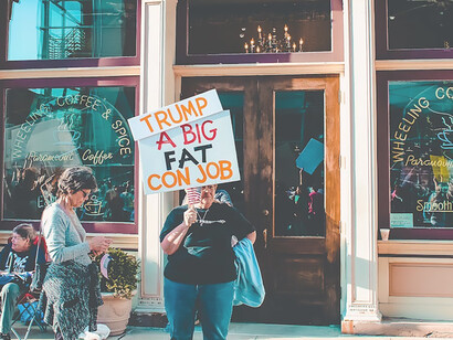 Community demonstrates civic engagement, holding banner outside building ahead of US elections