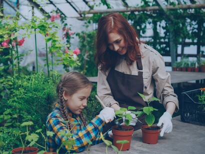 A woman and child tending to potted plants together, representing how everyday activities can nurture both health and wellbeing