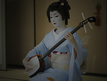 At Ryuhonji Temple, Kyoto geiko Toshimana captivates with her Shamisen performance, adorned in full makeup, a katsura wig, and exquisite traditional attire, including a single rose kanzashi hairpin, a blue hikizuri kimono, and a luxurious brocade obi