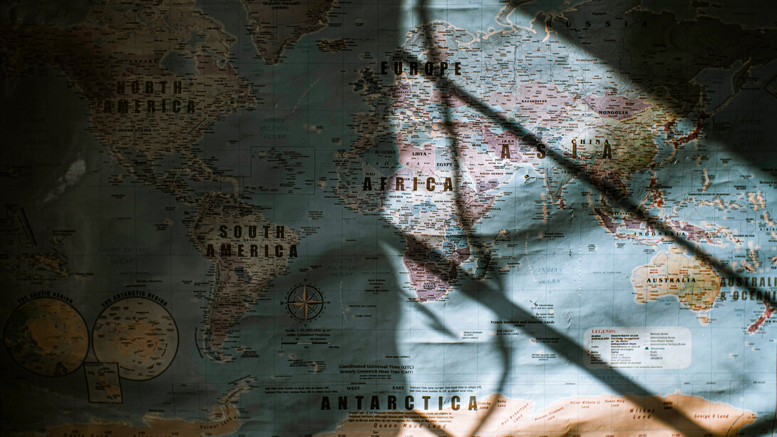 Mapa del mundo iluminado parcialmente por la luz que atraviesa una ventana