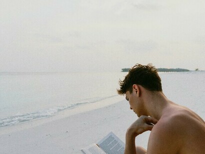 Persona leyendo en la playa. El libro adecuado puede guiar a un estudiante entusiasta en la dirección correcta