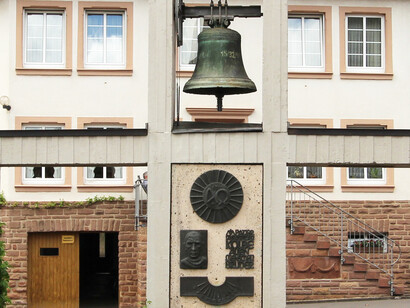 El monumento a Maximilian Kolbe con fuente y reloj de sol en la explanada de la iglesia de Mettendorf, Alemania