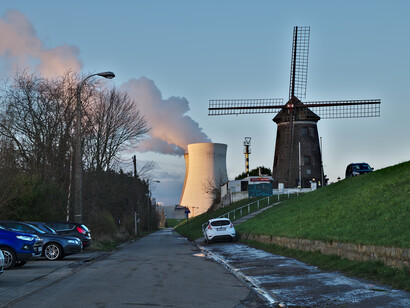 Cuando se disparan partículas para separar un átomo de Uranio (o similar) en átomos más pequeños, no se aprovecha nada de esa gigantesca energía, sino solo el calor que esta reacción genera. "De Molen" (molino de viento) y la torre de enfriamiento, 2018, Doel, Bélgica