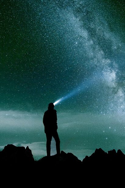 A lone silhouette beneath a vast starry night, reaching toward the heavens in quiet wonder
