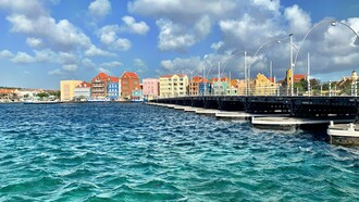 The vibrant waterfront of Willemstad’s Punda district—where Dutch colonial architecture meets Caribbean color—invites visitors to stroll, sip a Blue Lagoon, and watch history ripple across Santa Anna Bay